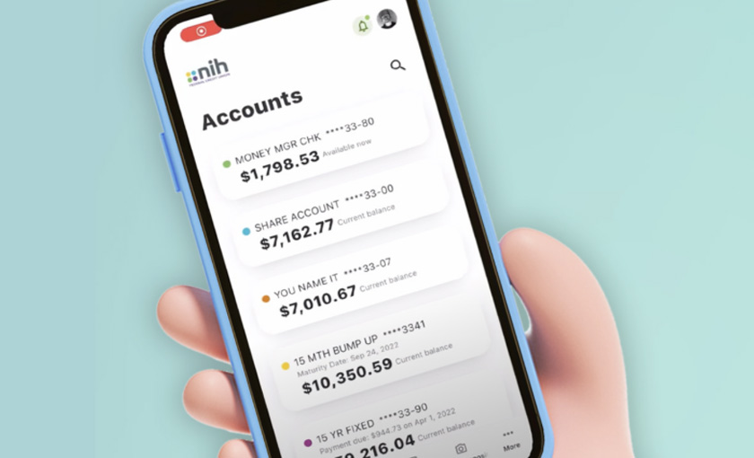 Hand holding a mobile phone displaying the NIHFCU mobile app